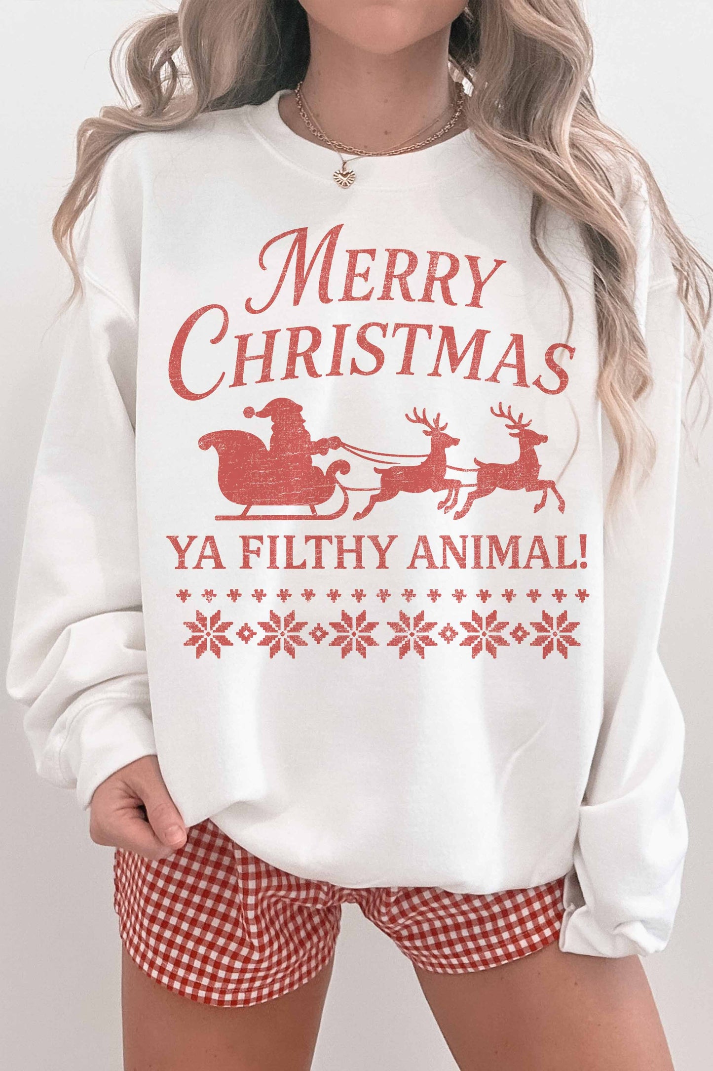 White sweatshirt with red Christmas text and graphics, paired with red checkered shorts.
